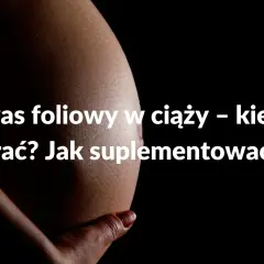 Brzuch kobiety w ciąży z napisem: Kwas foliowy w ciąży – kiedy brać? Jak suplementować?