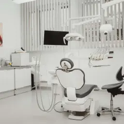 Nowoczesny gabinet stomatologiczny z fotelem dentystycznym i obrazem ust.
