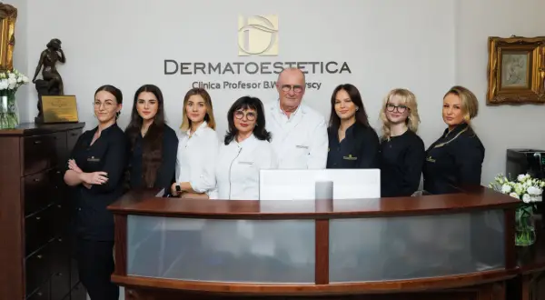 Zespół dermatologów i personelu kliniki estetycznej "Dermatoestetica" za ladą.
