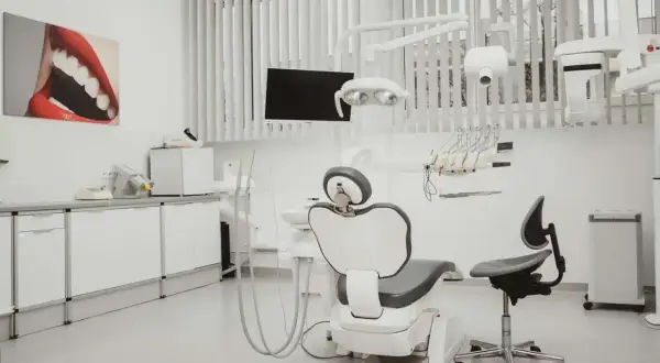 Nowoczesny gabinet stomatologiczny z fotelem dentystycznym i obrazem ust.